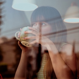 Naine mõtiskleb kohvikus