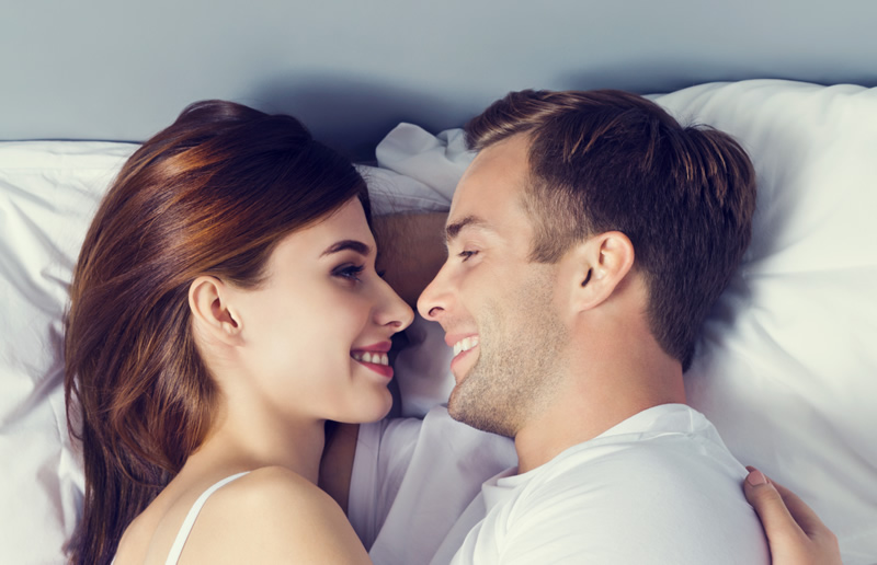 Armastus: naeratav paarike voodis